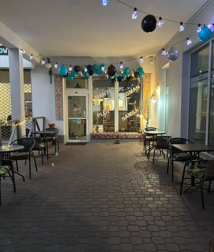 Pasaż z girlandą żarówek i stolikami